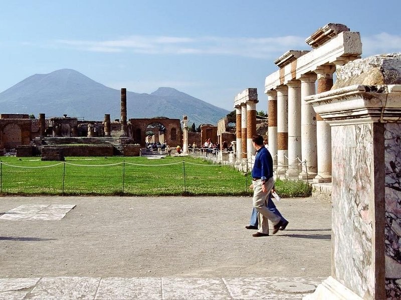 The open square of the Forum at Pompeii, the cone of Vesuvius beyond the colonnade