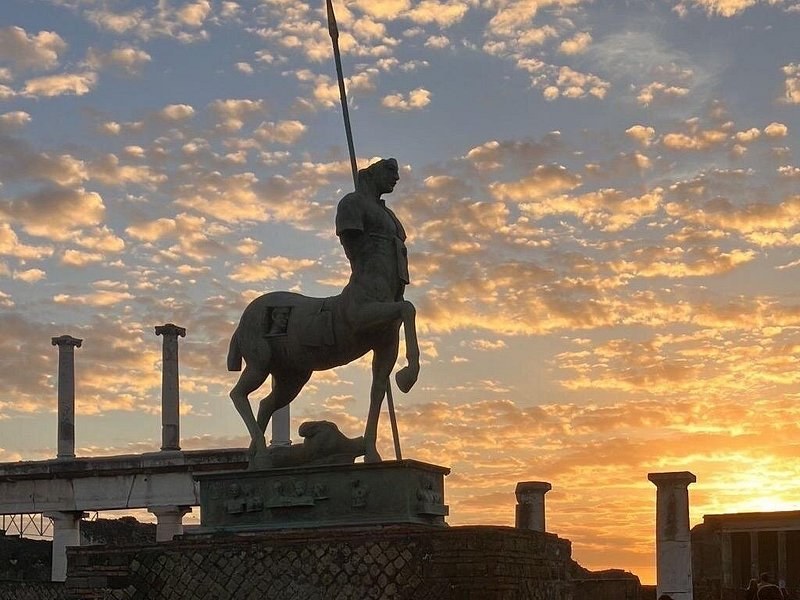 Sunrise over Pompeii, a bronze centaur silhouetted on its plinth in the Forum